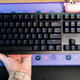 A photo of a hand holding up the Razer Huntsman V2 mechanical keyboard